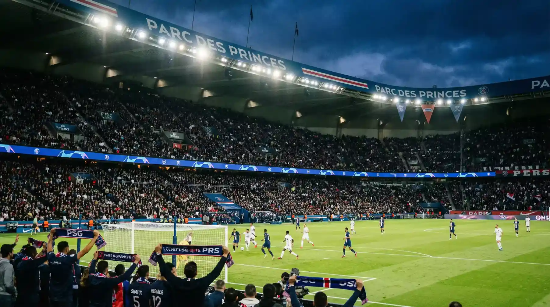 Estadio del PSG con aficionados animando durante un partido de Ligue 1