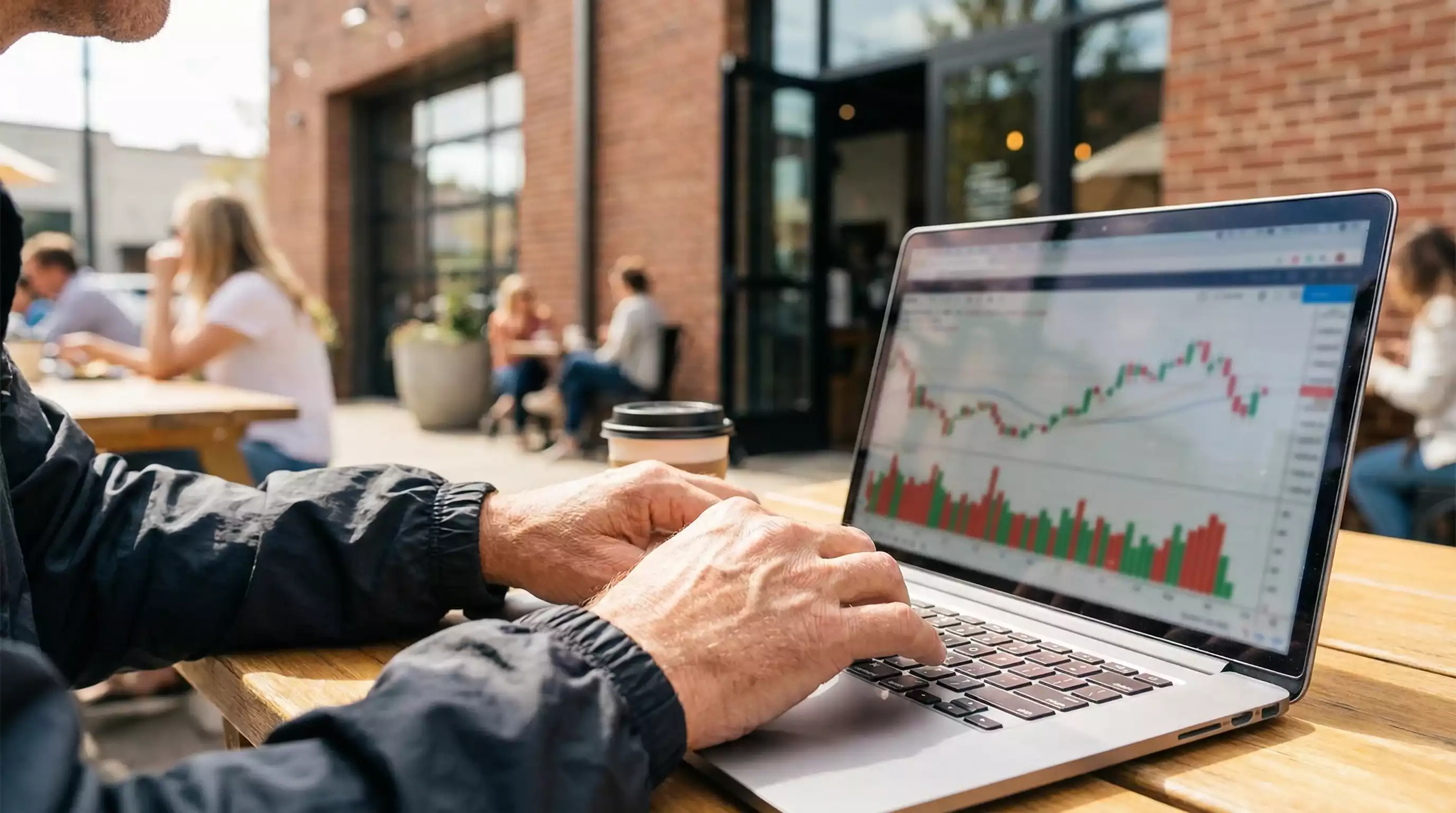 Manos de persona usando ordenador portátil con gráficos de control financiero
