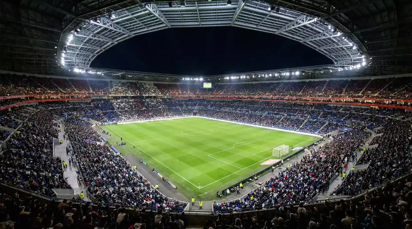 Groupama Stadium de Lyon iluminado durante partido nocturno de Ligue 1