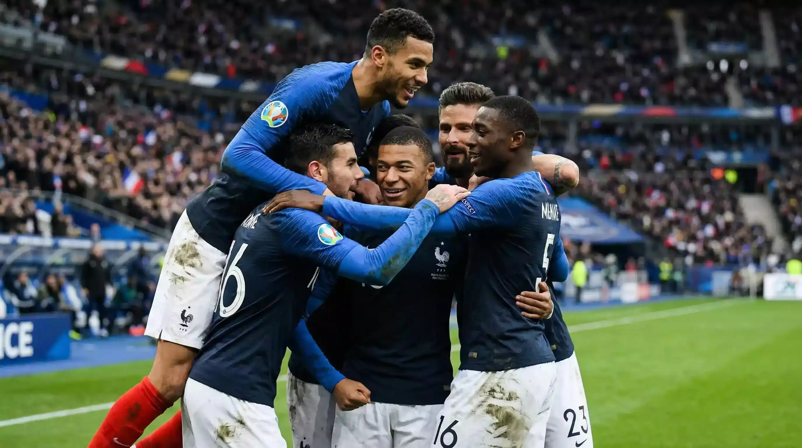 Celebración de gol en partido de fútbol francés con jugadores abrazándose