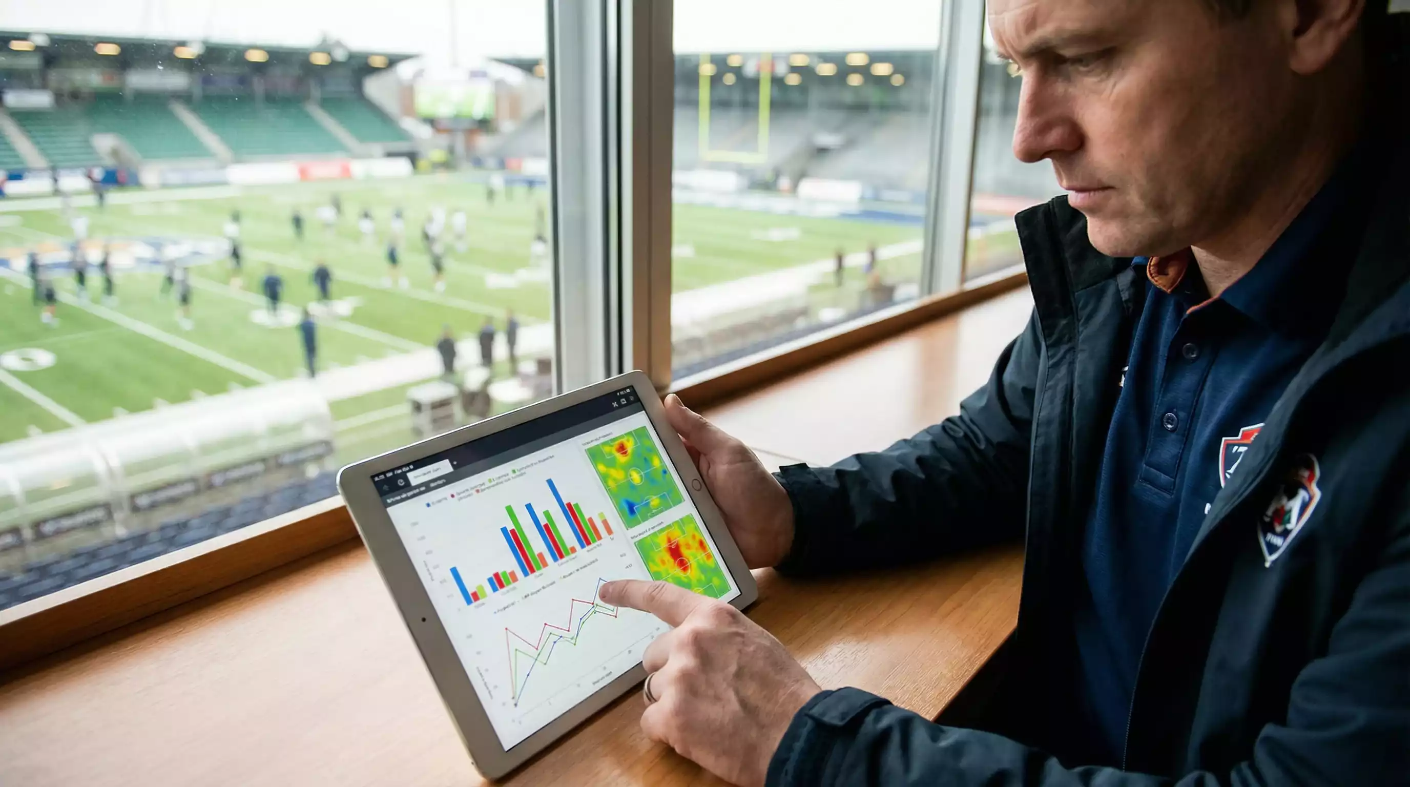 Persona analizando estadísticas de fútbol en tablet con gráficos